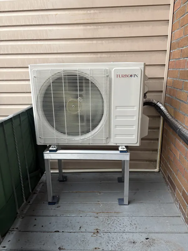 Unité extérieure installée sur une base surélevée sur un balcon